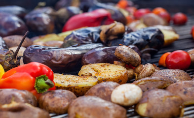 Red yellow green bell peppers potatoes mushrooms tomatoes and eggplant grilled until golden brown. The concept of proper nutrition and a healthy lifestyle. Cooking vegetables on the barbecue.