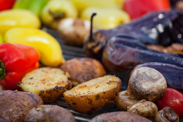 Red yellow green bell peppers potatoes mushrooms tomatoes and eggplant grilled until golden brown. The concept of proper nutrition and a healthy lifestyle. Cooking vegetables on the barbecue.
