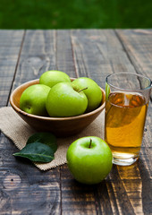 Apple juice glass with healthy green apples in wooden bowl