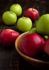 Naklejka na ściany i meble Green and red organic apples in bowl on wooden board