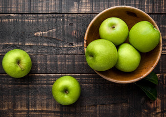 Green organic healthy apples in bowl on wooden board - Powered by Adobe