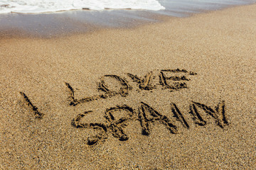 The words I Love Spain written in the sand on beach