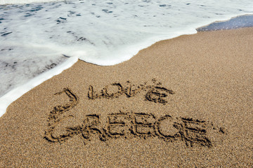 The word I Love Greece written in the sand on beach