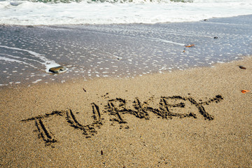 The word Turkey written in the sand on beach