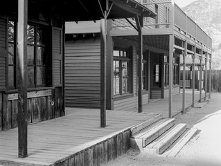 Dilapidated buildings with wooden sidewalks and dirt street from the old west