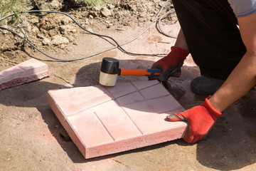 man cut red concrete paving slabs
