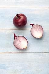 Fresh red onions on a blue wooden background