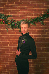 Wedding ideas, groom in black suit standing near decorated wall