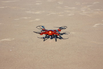 orange drone standing on the sand