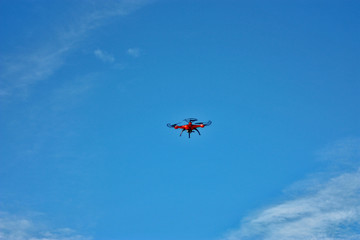 Fototapeta na wymiar orange drone flight on the blue sky