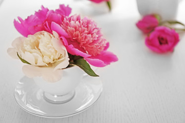 Bouquet of beautiful flowers in a cup on a  table