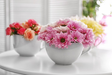 Bouquets of flower in cup on table