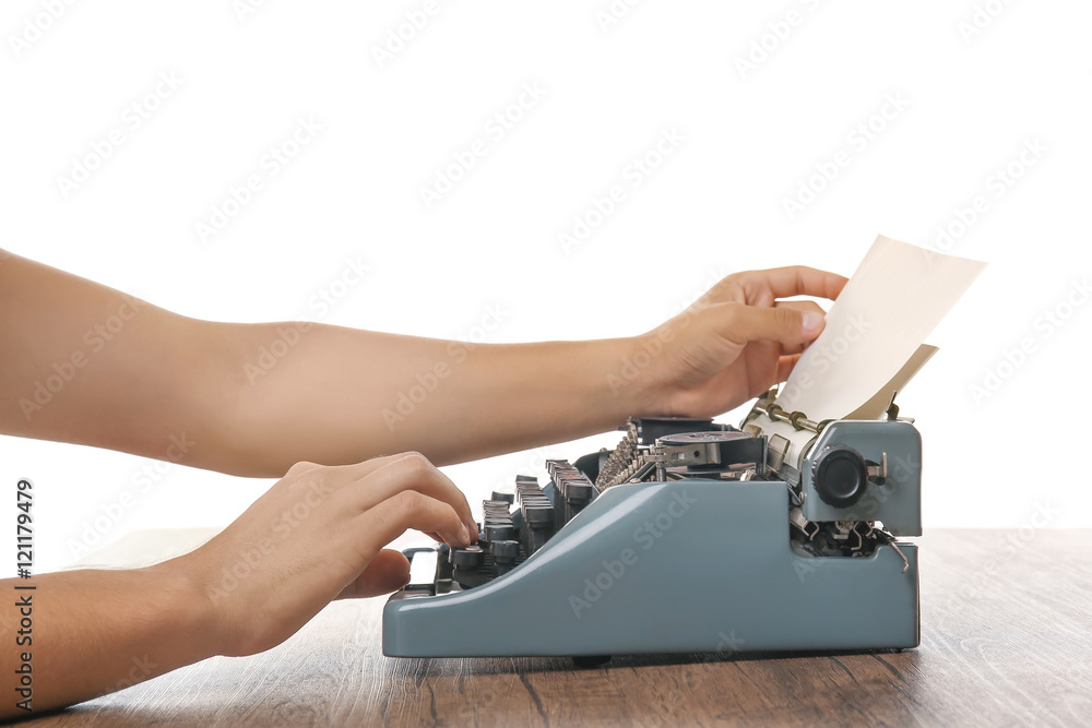Fototapete man working on retro typewriter at desk on white background
