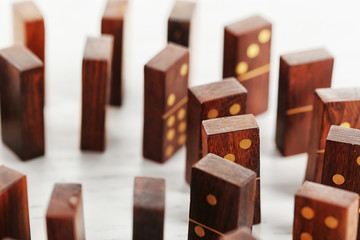 Circle of dominoes standing on light wooden background