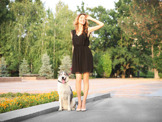 Young beautiful woman walking with dog outside