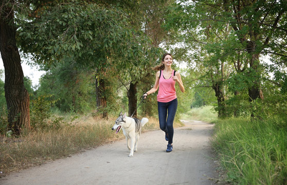 Woman walking with husky in park