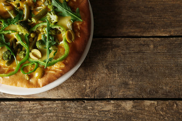 Tasty vegetarian pizza on wooden background