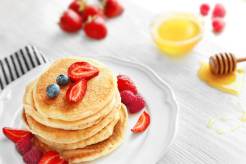 Tasty pancakes with fresh berries on plate