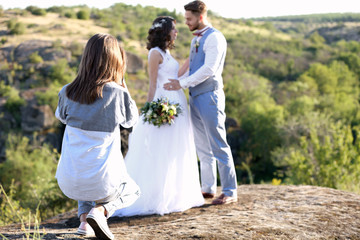 Wedding photographer taking photo of bride and groom - obrazy, fototapety, plakaty