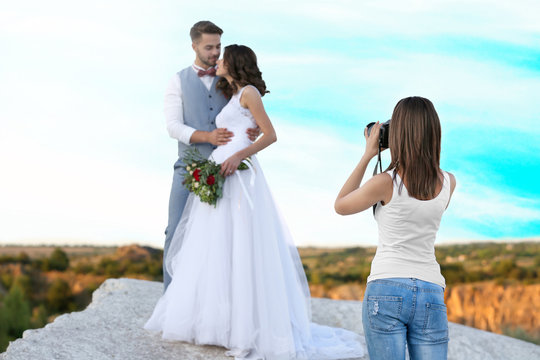 Wedding photographer taking photo of bride and groom