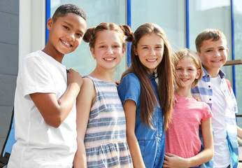 Group of pupils standing outdoors near school