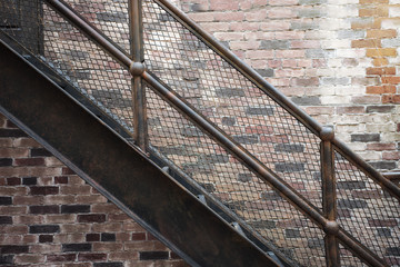 iron stairs set with patterned steps on the old brick background