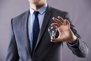 Businessman holding light bulb in creativity concept