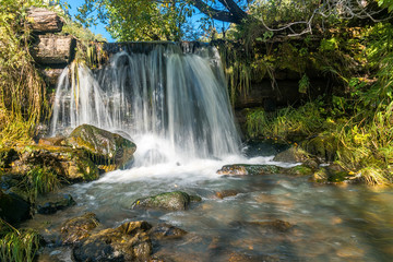Fototapeta na wymiar small waterfall on the creek