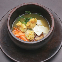 Top view of rice noodles soup with vegetable and dumplings

