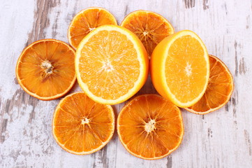 Dried and fresh orange on old wooden background