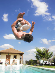 Man Diving Into Swimming Pool While Friends Wave