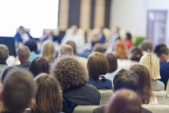 Business Concepts. People At the Conference Listening to Hosts Sitting at Round Table