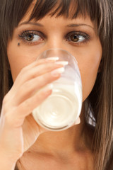 Portrait of young woman drinking milk isolated on white backgrou