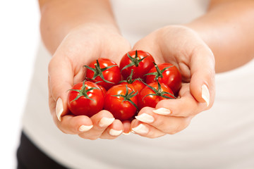 Young woman holding cherry tomatos in her hands. Close up, horiz