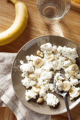 Overview of plate of cottage cheese with banana and nuts