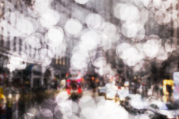 bokeh art background of road traffic in London on a rainy day through the bus window. raindrops on the glass window of the bus