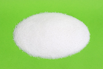 Pile of white sugar isolated on colored background