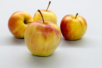 four red apple on white table