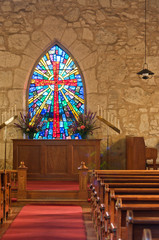 Interior of Christian Church with Sunlit Stained Glass Window. Vertical.