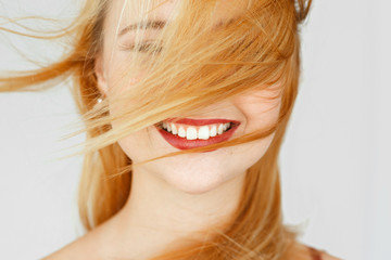 Perfect white smile of red-haired girl, close-up. Widely smiling happy carroty woman portrait. Good...