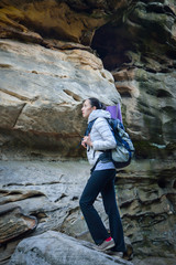 Fototapeta na wymiar Woman hiker walking with backpack big rock at background