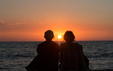 Two sisters watching the final sunset from a hawaiian vacation