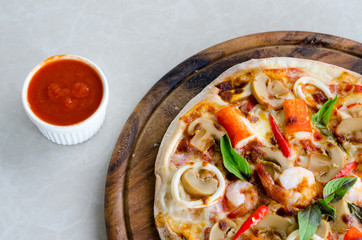 tomato sauce and Seafood Italian Pizza slice on wood dish