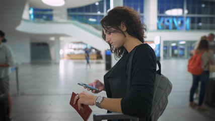 Woman at the airport holding the passport and thinking about the trip