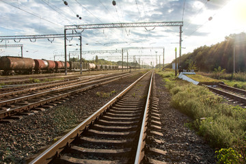 Fototapeta na wymiar Railway with freight train under cloudy sky