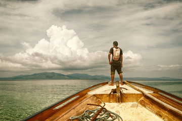 Traveler standing on a boat and looking at the islands