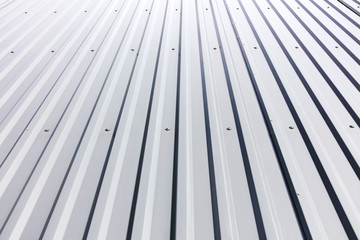 corrugated steel cladding with rivets on roof of industrial building 