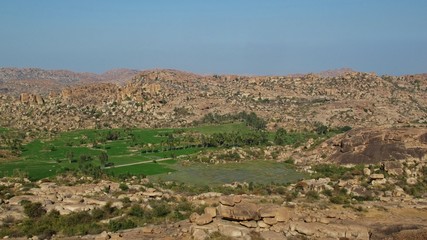 Rice fields in Hampi surrounded by granite mountains