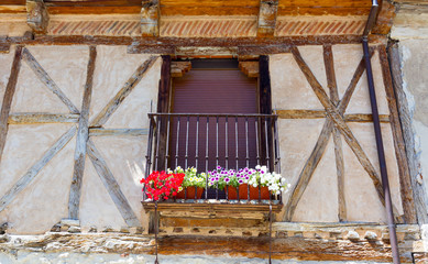 Fototapeta na wymiar balcony window with black grille and flowers