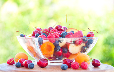 Fresh fruit salad in a glass bowl with ice outdoors